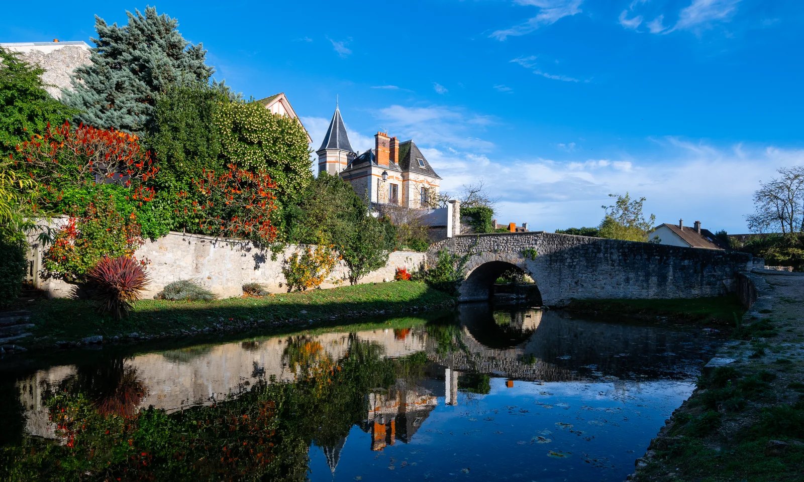 Pont de pierre et village de la Brie au bord de l’eau